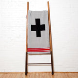 Grey knit throw blanket with black Swiss cross and red horizontal stripes, 50x60 inches.