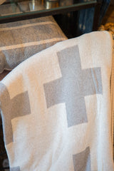 Knitted texture of the gray and white Swiss cross blanket pattern.