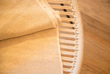Close-up of the woven texture on the natural beige recycled cotton blanket.