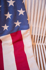 Textured knit red and cream stripes with white stars on an American Flag throw.