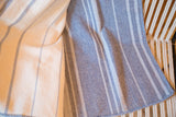 Double-sided blue woven blanket detail, showing cream stripes and chevron pattern.