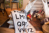 Eco Baby ABC Throw blanket with bold black letters knit into a white textile, gray border.