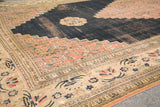 Corner of antique Doroksh carpet showing time-softened navy field, blush spandrel, and lily border.