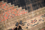 Detail of antique Persian Doroksh carpet, blush lily and vine border, contrasting dark navy, and localized wear.