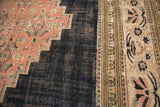 Antique Doroksh carpet with blush floral spandrel, stepped contour, and worn navy blue field.