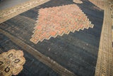 Antique Doroksh carpet showing distressed dark navy field with exposed foundation and blush medallion.