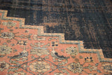 Distressed dark navy field and blush floral spandrel with stepped contour on antique Doroksh rug.