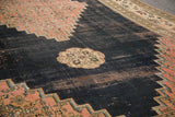 Distressed dark navy field, blush stepped pattern, exposed foundation on a Persian Doroksh rug.