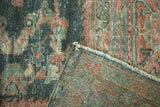Distressed vintage Mahal carpet corner revealing textured pile, restrung edge, and foundation.