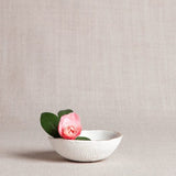 Handmade porcelain ring dish with a textured white exterior and a 22k gold luster rim.