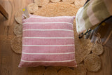 Hand-woven throw pillow in wine red with cream horizontal stripes, 20x20 inches.