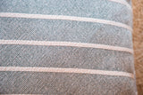Textural detail of hand-woven hunter green cotton pillow with off-white stripes.