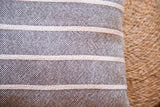 Textured black hand-woven pillow featuring light horizontal stripes and cotton weave.