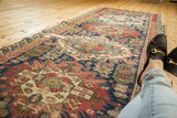 Geometric motifs and rectilinear flowers on a vintage Seichor runner with reciprocating wave border.