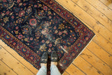 Persian Yezd rug corner, indigo field, cochineal red floral vinery border, tattered side.