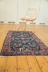 Vintage Yezd rug with indigo field, delicate vinery, red and gold floral motifs, and wear.