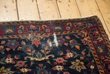 Vintage Yezd rug corner with indigo floral vinery, red border, and areas of pile loss.