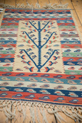 Germinating blue tree of life motif with colorful banded patterns on an ivory vintage Kilim.