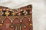 Close-up of vintage Kilim pillow's woven geometric patterns in rust, brown, and cream.