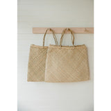 Two square seagrass bags displaying natural hand-woven texture and braided handles.