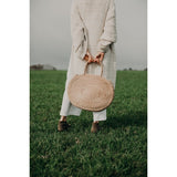 Round seagrass bag with natural woven texture.