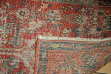 Folded corner of an antique Heriz runner revealing its hand-knotted back and low, worn pile.