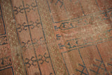 Faded blush, navy primitive garden motifs, and exposed foundation on antique Turkmen rug.