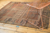 Antique Turkmen rug corner showing dark blue geometric border and tattered, exposed foundation.