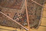 Antique Turkmen rug corner, faded blush and navy primitive geometric panels, exposed foundation.
