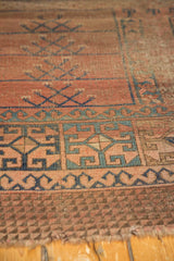 Antique Turkmen rug detail: primitive repeating panels in dusty rose, navy, and teal with exposed foundation.