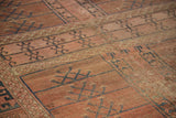 Primitive motifs, muted rose-red hues, and visible foundation texture on antique Turkmen rug.