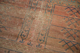 Antique Turkmen rug's worn pile reveals exposed foundation and primitive blush-and-navy patterns.