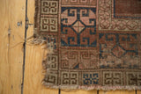Hard tatter, exposed foundation, and blush blue geometric pattern on an antique Turkmen rug.