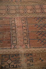 Faded blush and navy primitive garden motif on antique Turkmen rug, with exposed foundation.