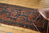 Vintage Hamadan rug with triple shadow medallions and germinating plants in brick red and navy.