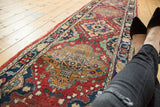 Vintage Tabriz runner with cherry red field, gold medallion detail, and a wide vine border.
