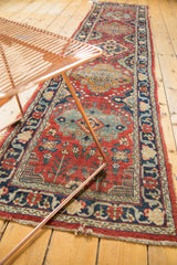 Vintage Tabriz runner featuring low pile, cherry red floral field, and navy vine border.