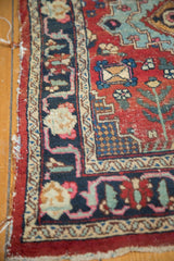 Vintage Tabriz runner side border, navy meandering vine, cherry red field, and tattered edge.