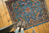 In-situ view of a vintage Persian rug with expressive floral vinery on a sky blue field.
