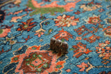 Even, full pile of a vintage Fine Engelas rug with red and green floral vinery on a blue field.