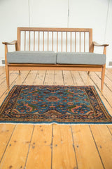 Vintage Engelas collector rug with floral vinery on a blue field, shown for scale and context.