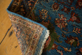 Close-up of the vintage rug's corner showing the hand-knotted back and secured blue edge.