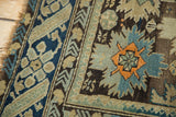Antique Caucasian rug corner detail, showing etched knot heads, teal starburst, and faded blue border.
