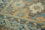 Antique Caucasian rug detail: sky blue and pale bronze starbursts, tribal motifs, deep blue border.