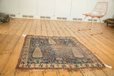 Antique Afshar rug's hand-knotted texture, visible wear, and distinctive tattered fringe.