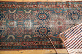 Vintage Lilihan runner with dusty rose, indigo, teal Herati floral motifs and wear.