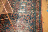 Vintage Lilihan runner showing dusty rose and indigo geometric patterns, visible wear, and tattered side.