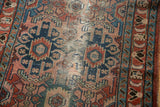 Dusty rose and indigo blue patterns on a vintage Lilihan rug with localized foundation wear.