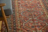 Antique Persian Malayer rug's terra cotta field, indigo floral patterns, and green scalloped details.
