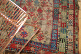 Hand-knotted Caucasian rug detail: geometric germinating flowers, border, and visible knot heads.